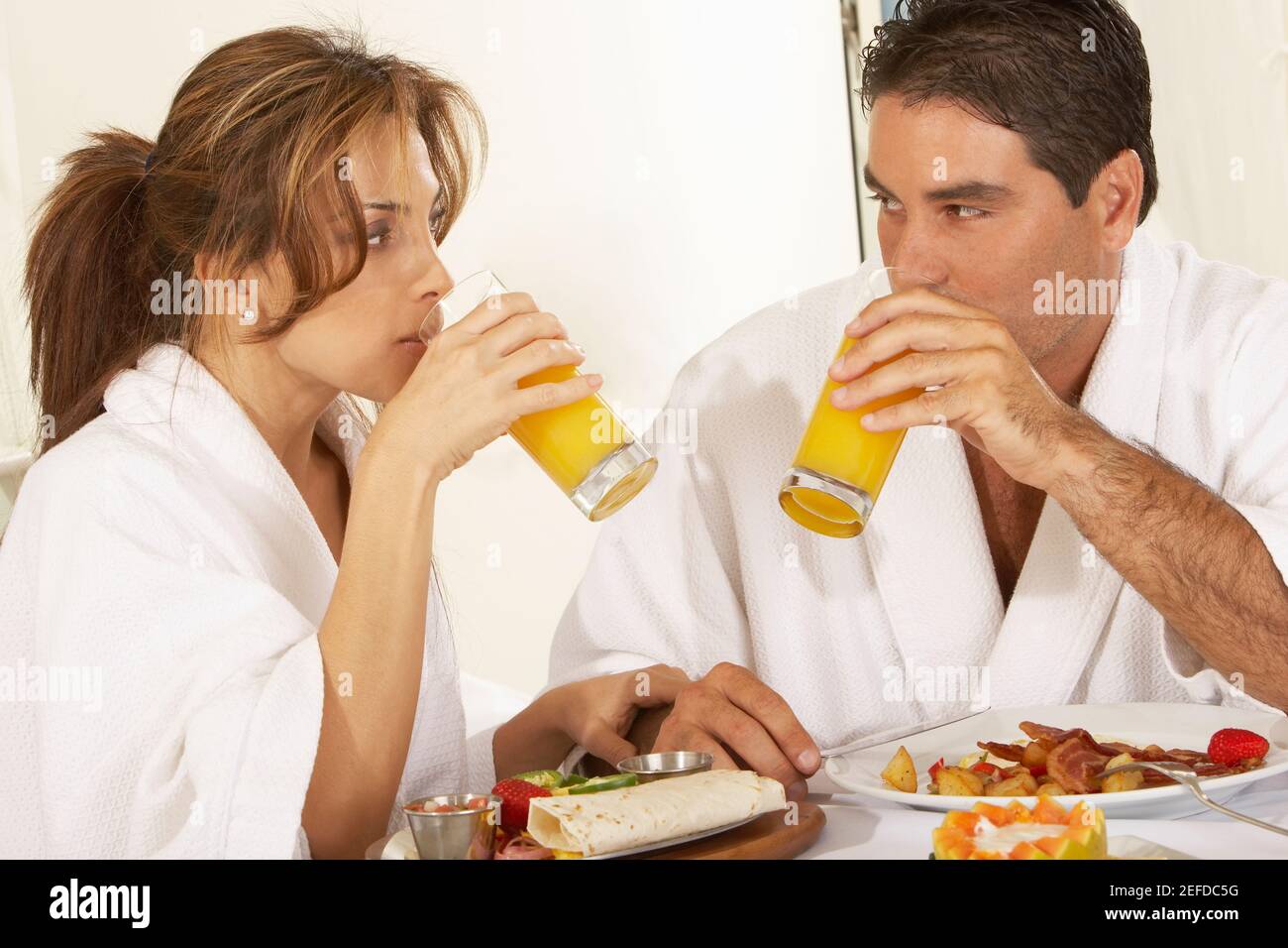 Nahaufnahme eines mittelerwachsenen Paares, das sich ansieht Saft trinken Stockfoto