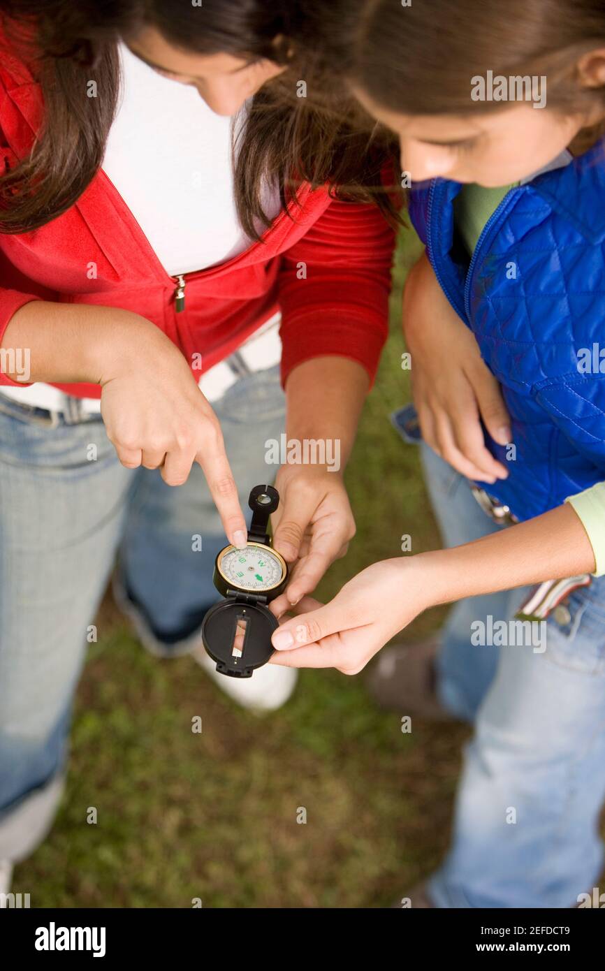 High-Angle-Ansicht von zwei Mädchen im Teenageralter mit einem antiken Kompass Stockfoto