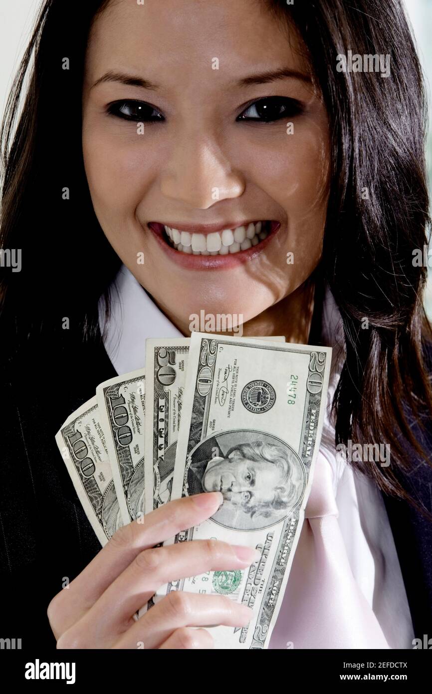 Porträt einer Geschäftsfrau, die amerikanische Dollarscheine hält Stockfoto