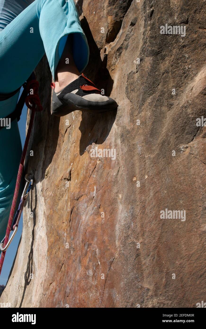 Low-Section-Ansicht einer Kletterin, die einen Felsen erklimmen Gesicht Stockfoto