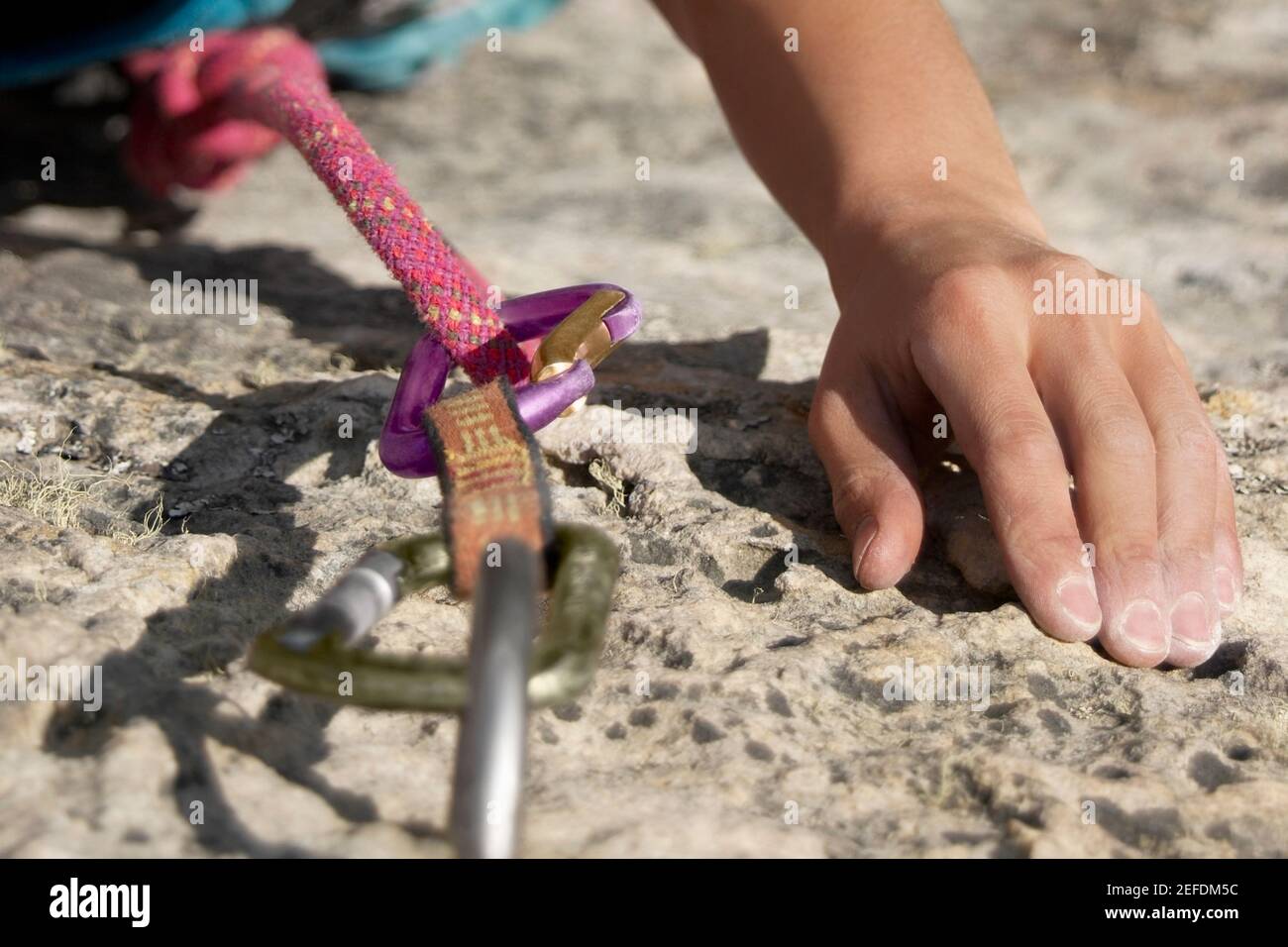 Hände eines Felskletterners, der einen Felsen ergreift Stockfoto