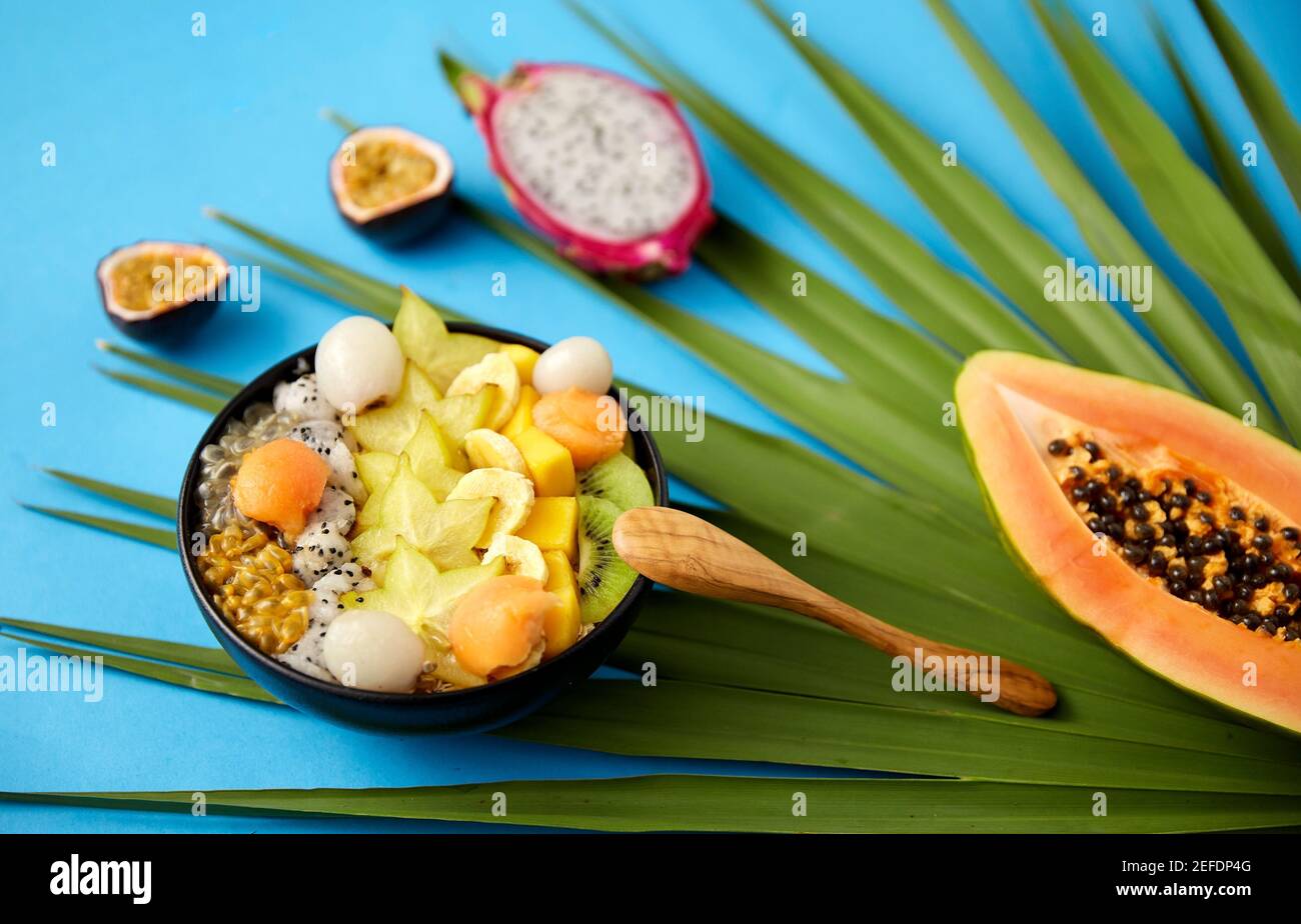 Mischen Sie exotische Früchte in einer Schüssel mit einem Holzlöffel Stockfoto