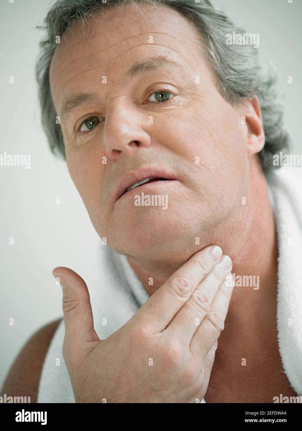 Porträt eines reifen Mannes, der seinen Hals berührt Stockfoto