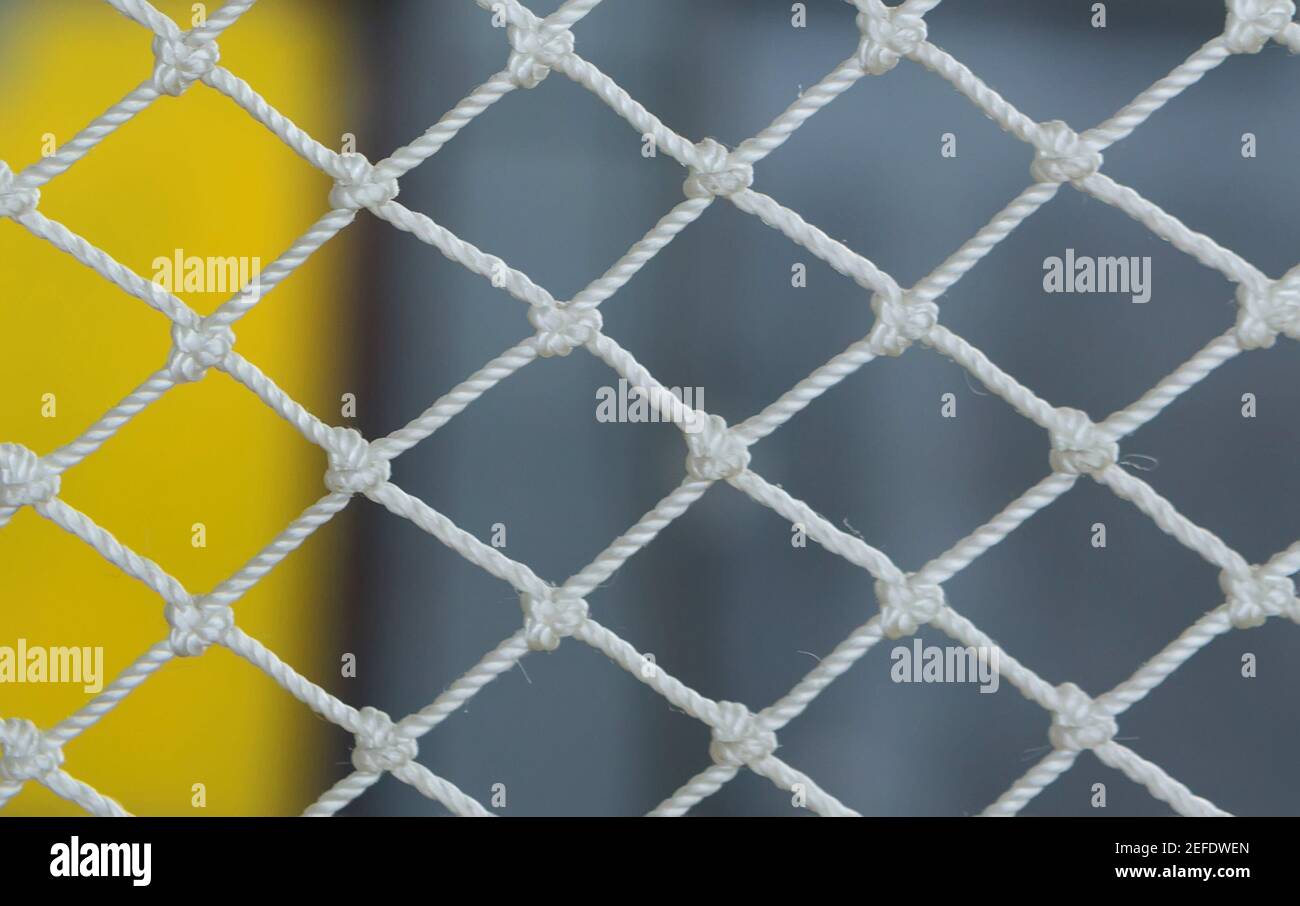 Weißes Netz auf gelb-grauem abstraktem Hintergrund mit selektivem Fokus Stockfoto