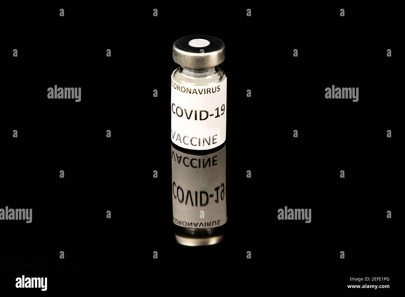 Coronavirus Covid 19 Impfkonzept. Kleine Glasflasche mit silbernem Deckel und Etikett auf schwarzem Hintergrund Stockfoto