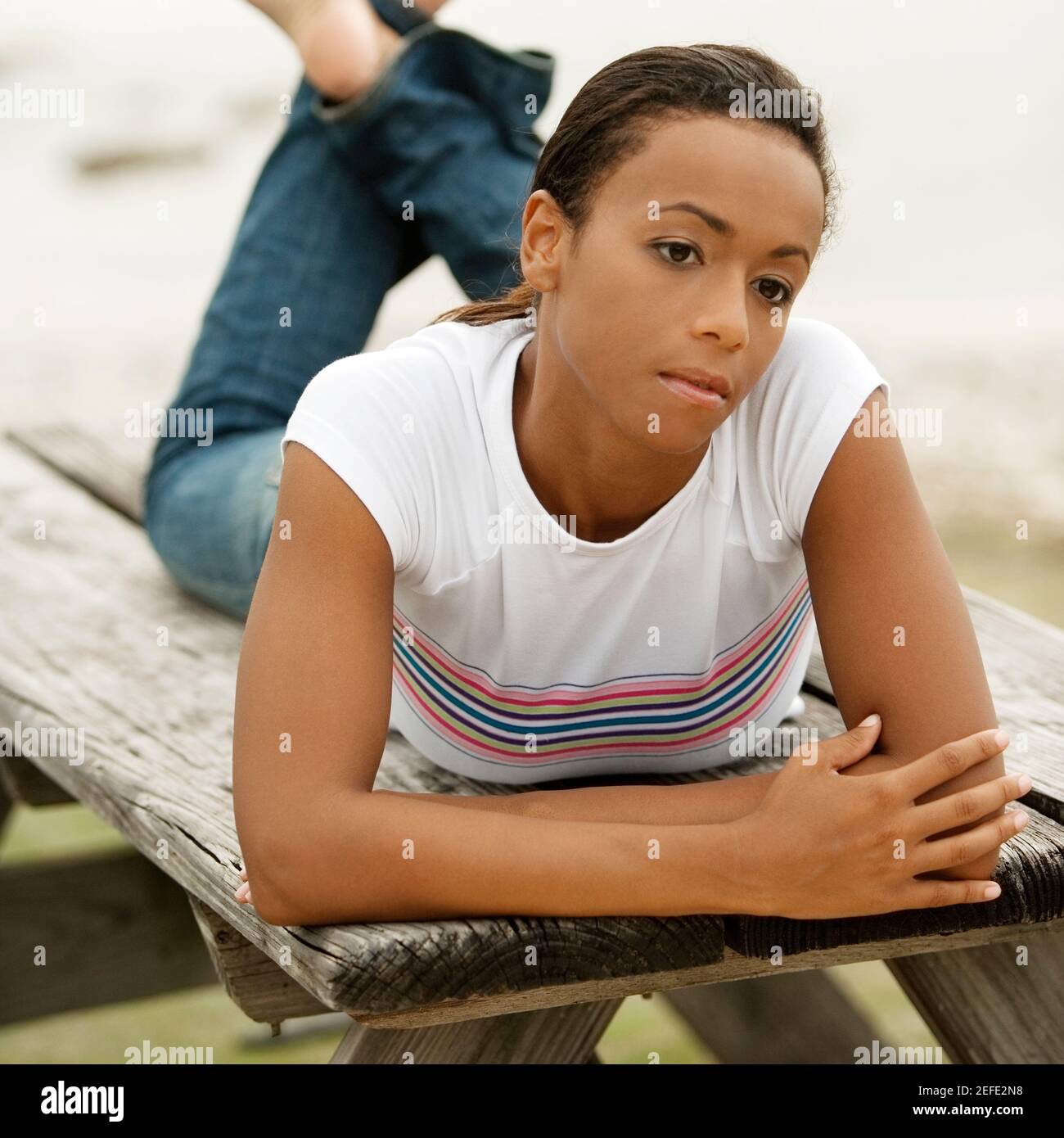 Nahaufnahme einer jungen Frau, die auf einer Bank liegt Stockfoto