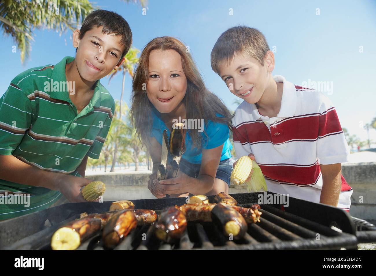 Porträt einer mittleren erwachsenen Frau mit ihren Kindern beim Barbecue Stockfoto