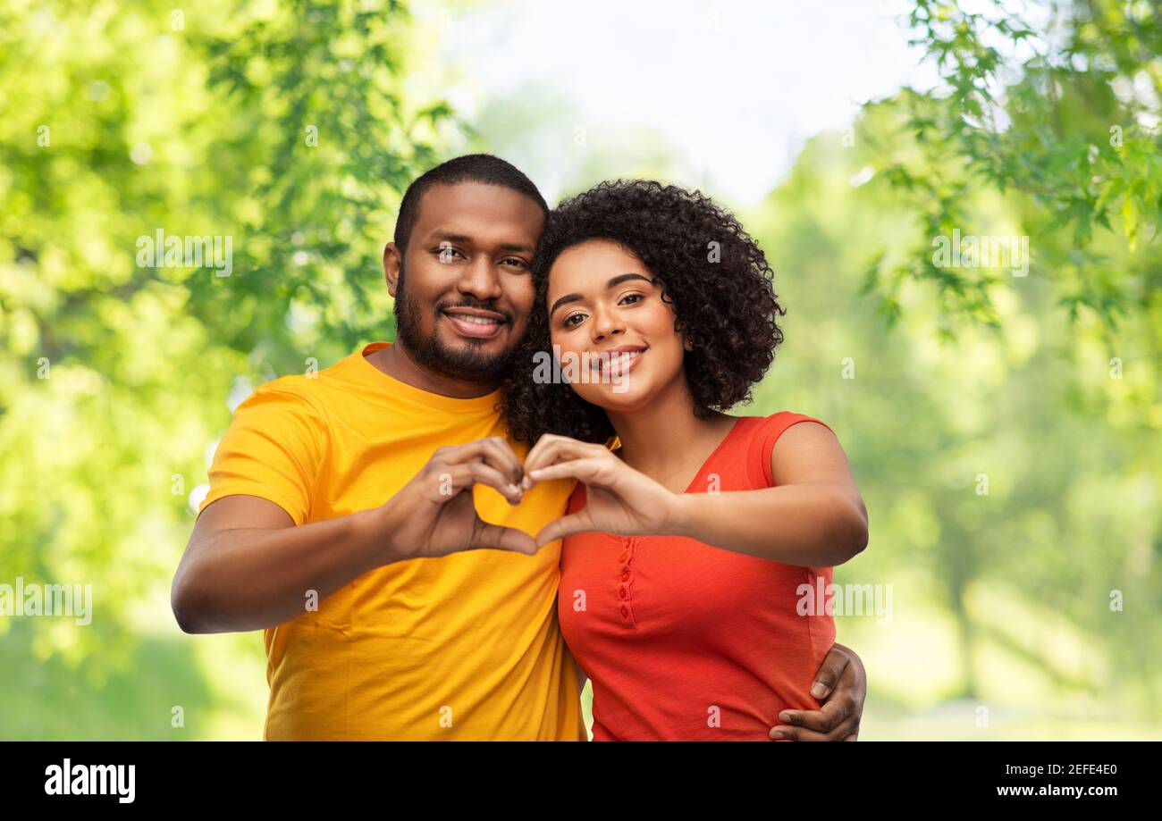 Glückliches afroamerikanisches Paar, das Hand Herz macht Stockfoto