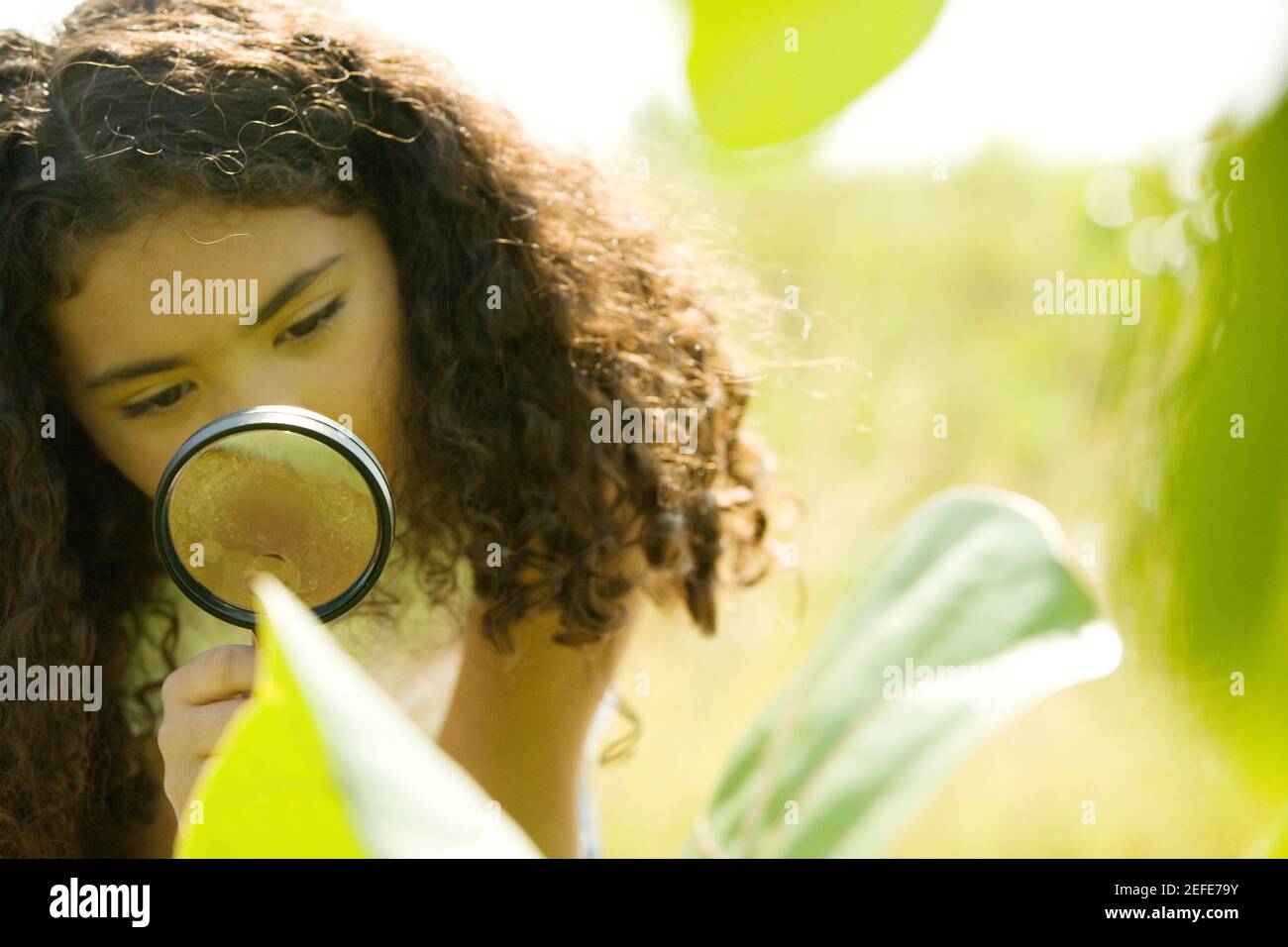 Nahaufnahme eines Mädchens Blick durch eine Lupe Stockfoto