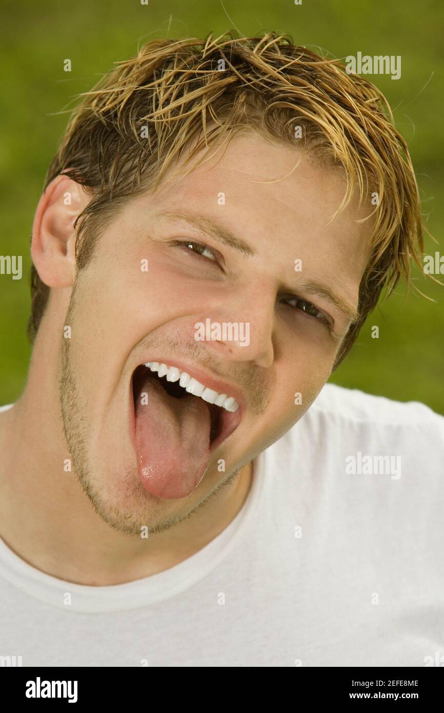Porträt eines jungen Mannes heraus seine Zunge Stockfoto