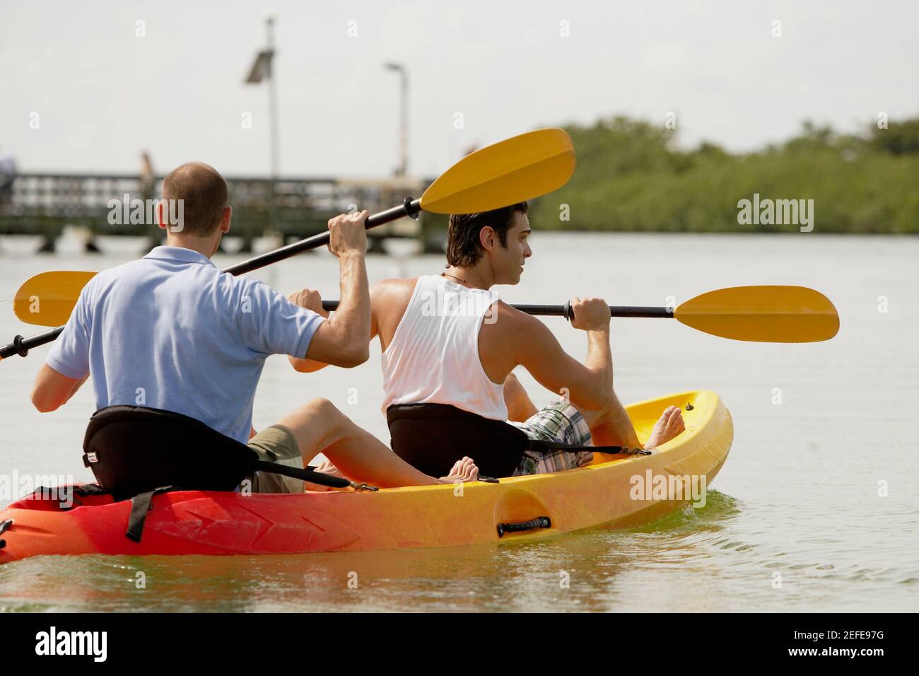 Rückansicht von zwei jungen Männern beim Kajakfahren Stockfoto