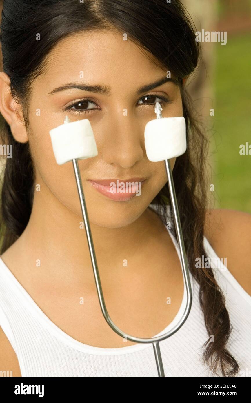 Porträt eines Teenagers, das Marshmallows auf einem Spieß hält Stockfoto