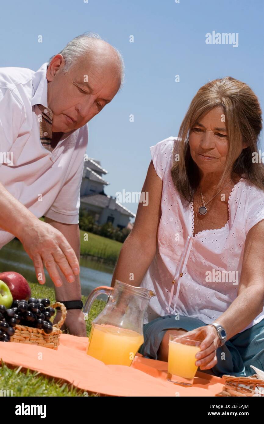 Ältere Paare genießen Saft beim Picknick Stockfoto