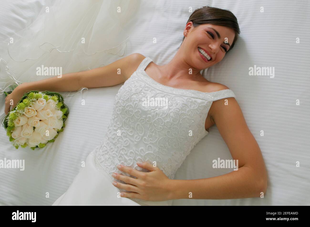 Hochwinkelansicht einer Braut, die auf dem Bett liegt Und lächelnd Stockfoto