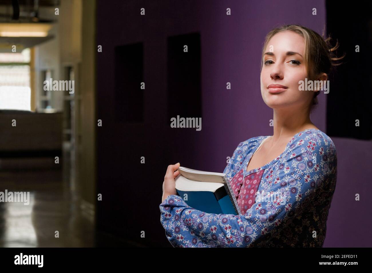 Porträt einer jungen Frau hält Bücher und lächelnd Stockfoto
