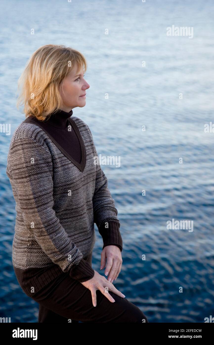 Seitenprofil einer reifen Frau, die am Meer denkt Stockfoto