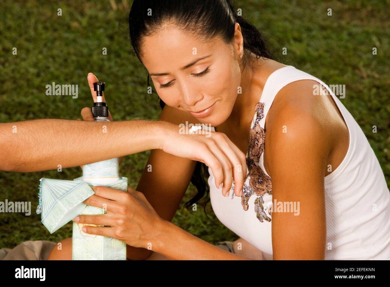 Nahaufnahme einer jungen Frau mit einer Flasche Lotion Stockfoto