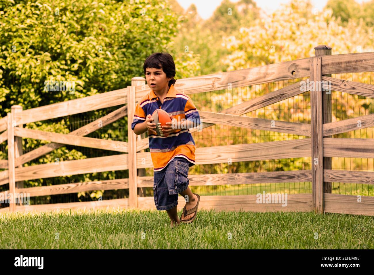 Junge mit einem Rugby-Ball spielen Stockfoto