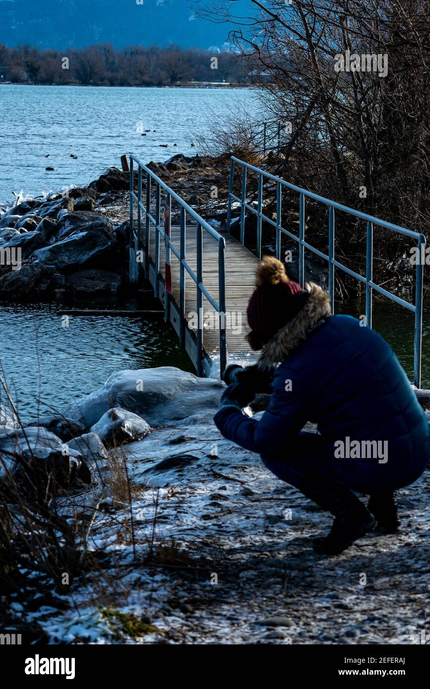 Fotograf bei der Arbeit am Ufer des Bodensees. Winter mit Eis. Bodensee mit vereistem Ufer lockt zum Fotografieren. Ingeborg Kuhn an der Arbeit Stockfoto