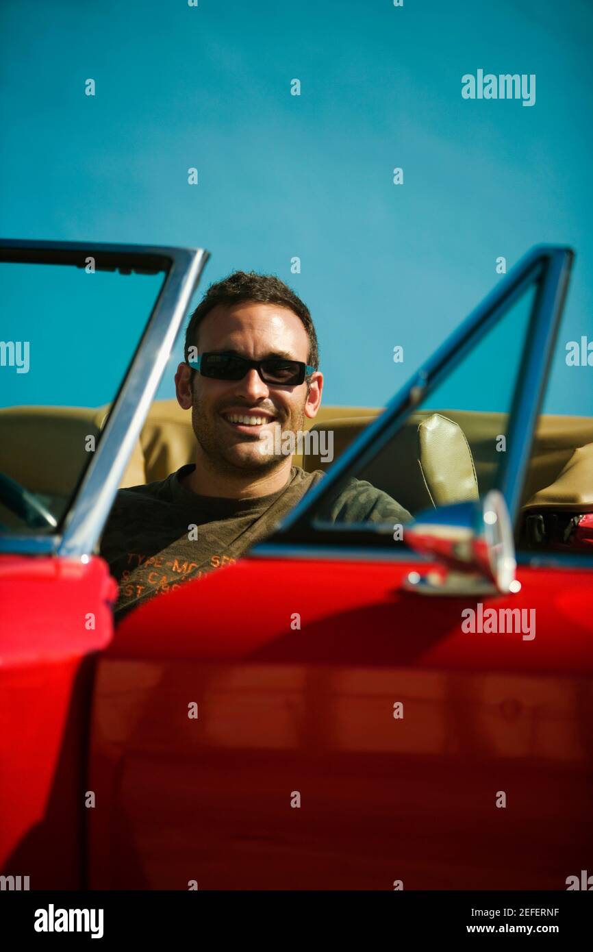 Nahaufnahme eines Mannes mit mittlerem Erwachsenen, der in einem Cabriolet sitzt, Miami, Florida, USA Stockfoto