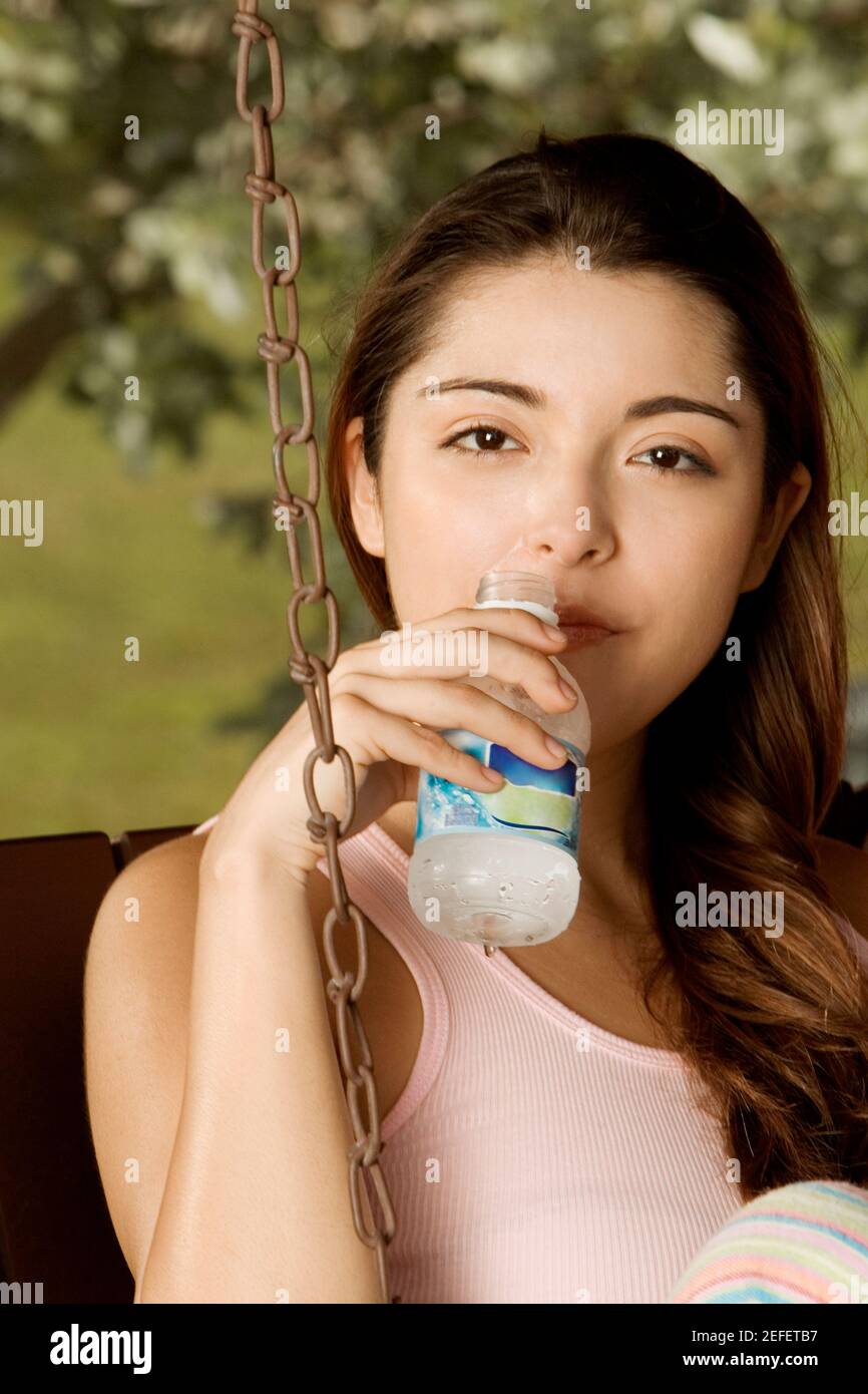 Porträt einer jungen Frau hält eine Flasche Wasser Stockfoto