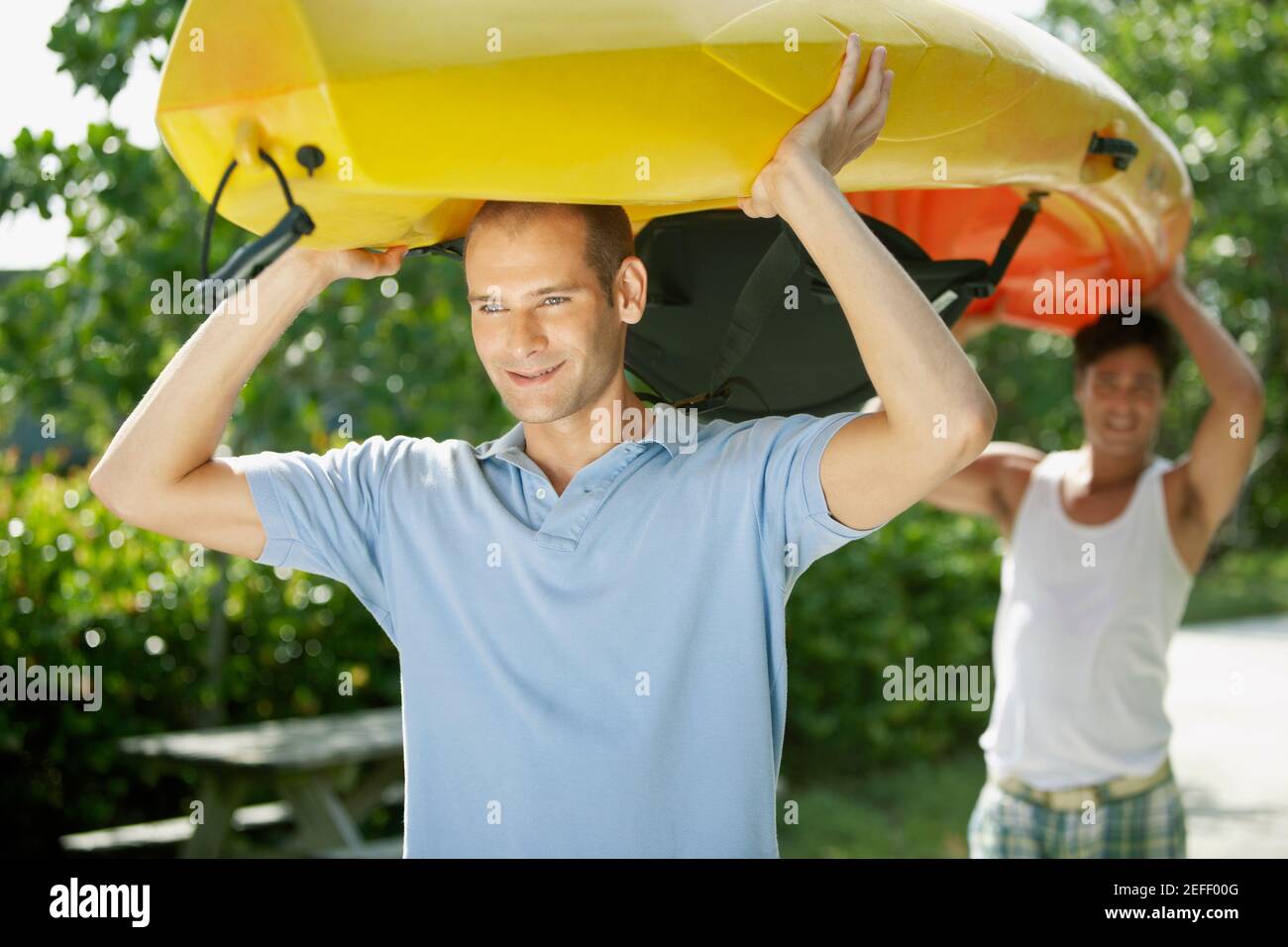 Nahaufnahme von zwei jungen Männern, die ein Kajak über ihren tragen Köpfe Stockfoto