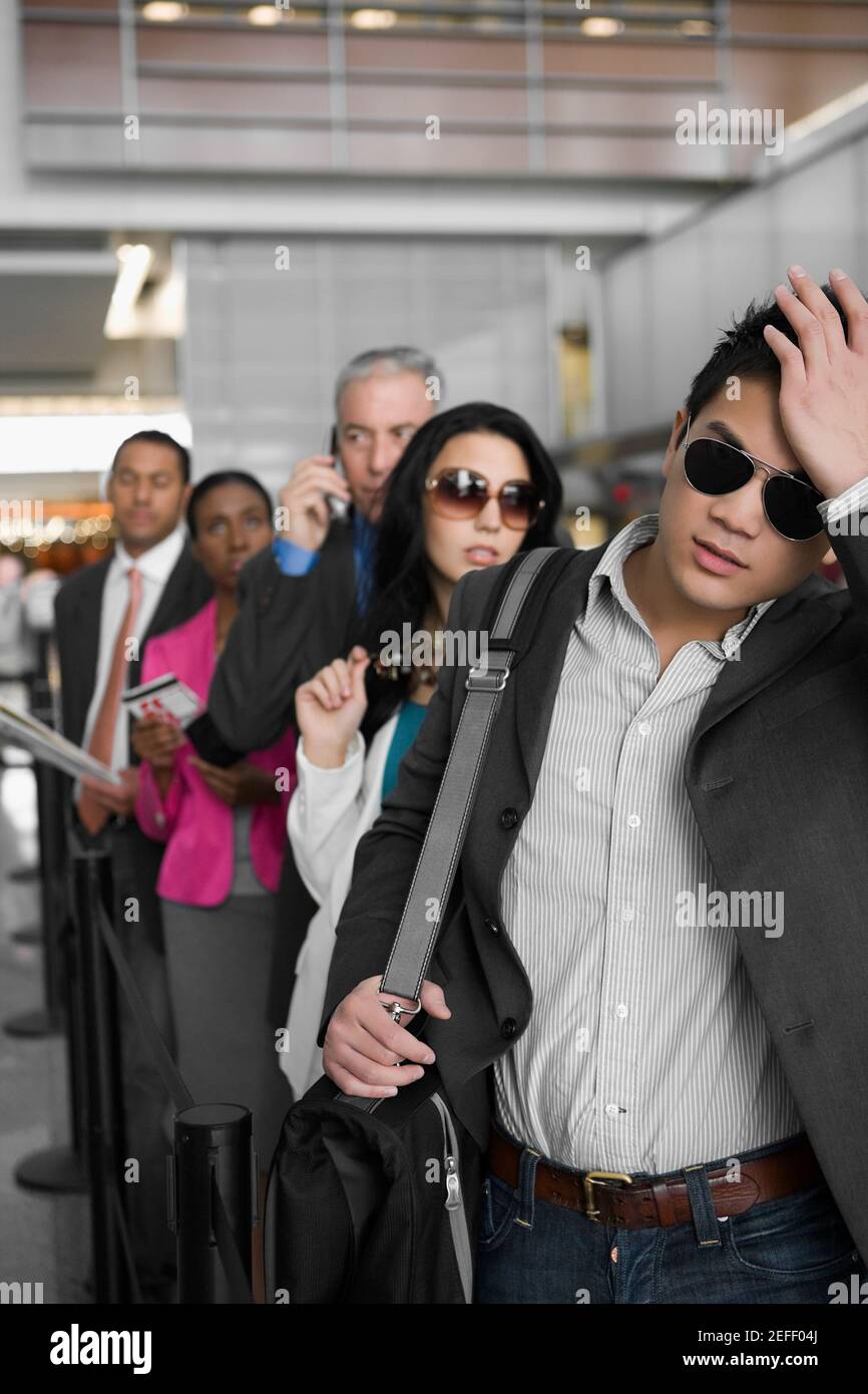 Geschäftsleute, die an einem Flughafen in einer Reihe stehen Stockfoto