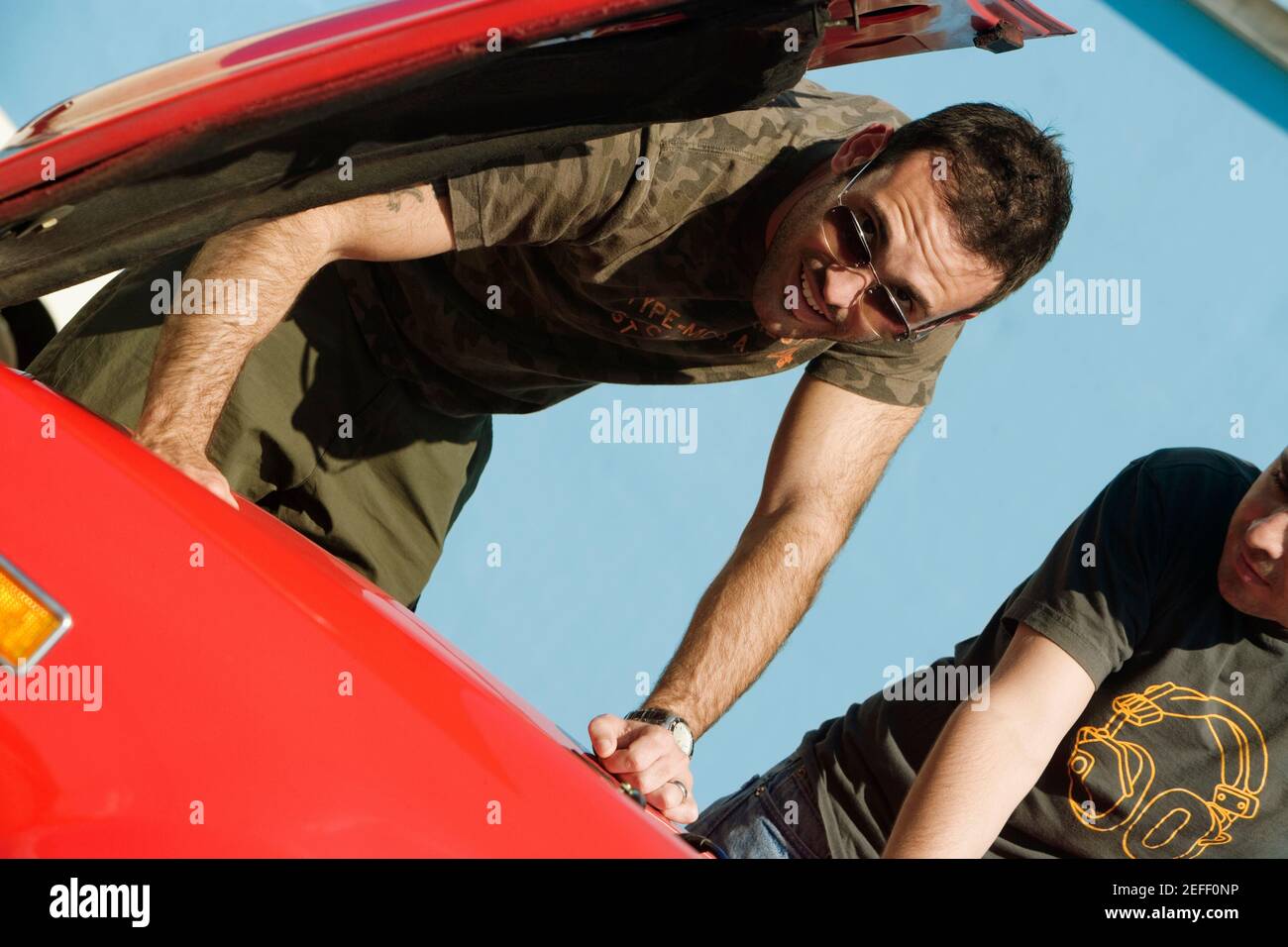 Low-Angle-Ansicht von zwei mittleren Erwachsenen Männer Untersuchung eines Auto-Motor, Miami, Florida, USA Stockfoto