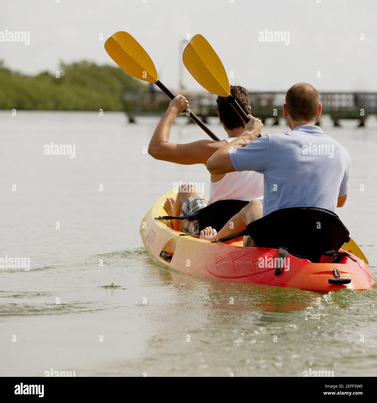 Rückansicht von zwei jungen Männern beim Kajakfahren Stockfoto