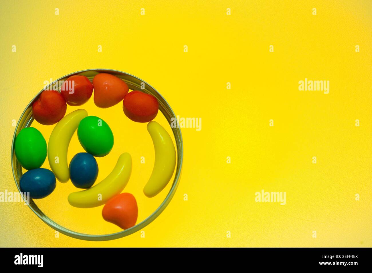 Nahaufnahme von verschiedenen Bonbons auf gelbem Hintergrund Stockfoto