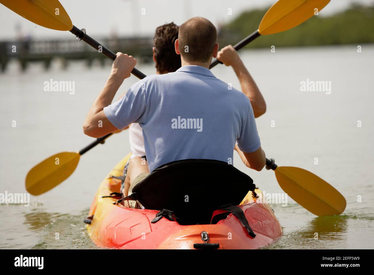 Rückansicht von zwei jungen Männern beim Kajakfahren Stockfoto