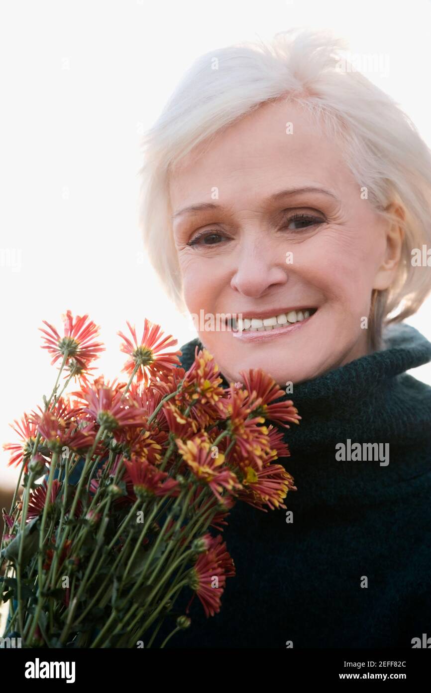 Porträt einer älteren Frau mit Blumenstrauß und Lächelnd Stockfoto