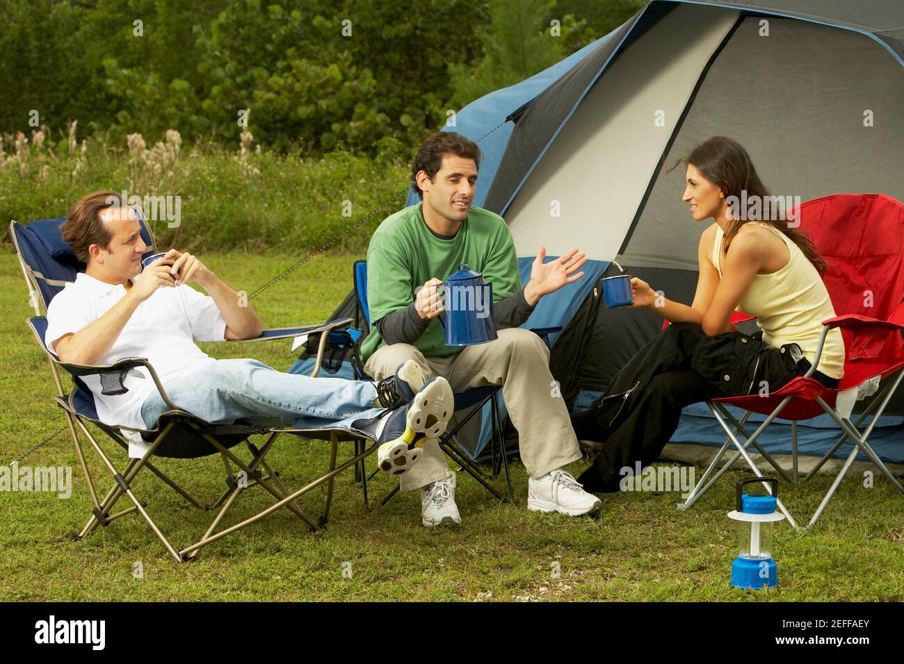 Frau mit mittlerem Erwachsenen und zwei Männer mit mittlerem Erwachsenen im Gespräch Einander Stockfoto