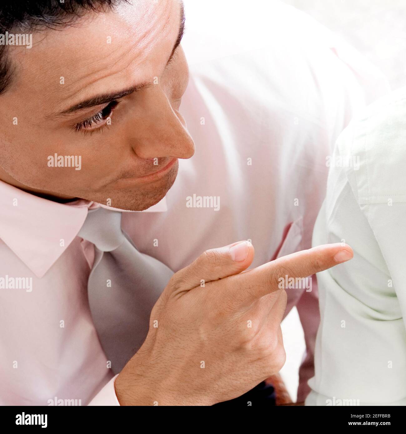 Nahaufnahme eines Geschäftsmannes, der auf einen anderen Geschäftsmann zeigt Stockfoto