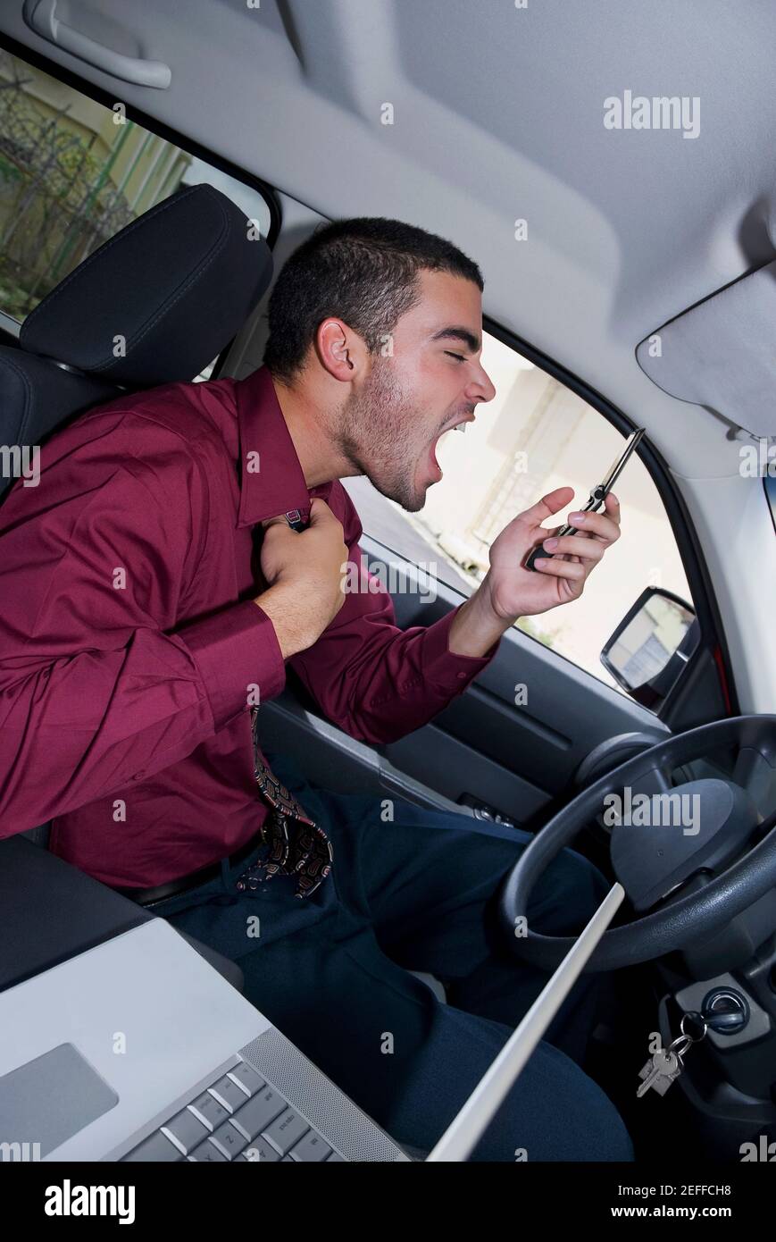 Seitenprofil eines Geschäftsmannes, der in einem Auto sitzt und Geschrei Stockfoto