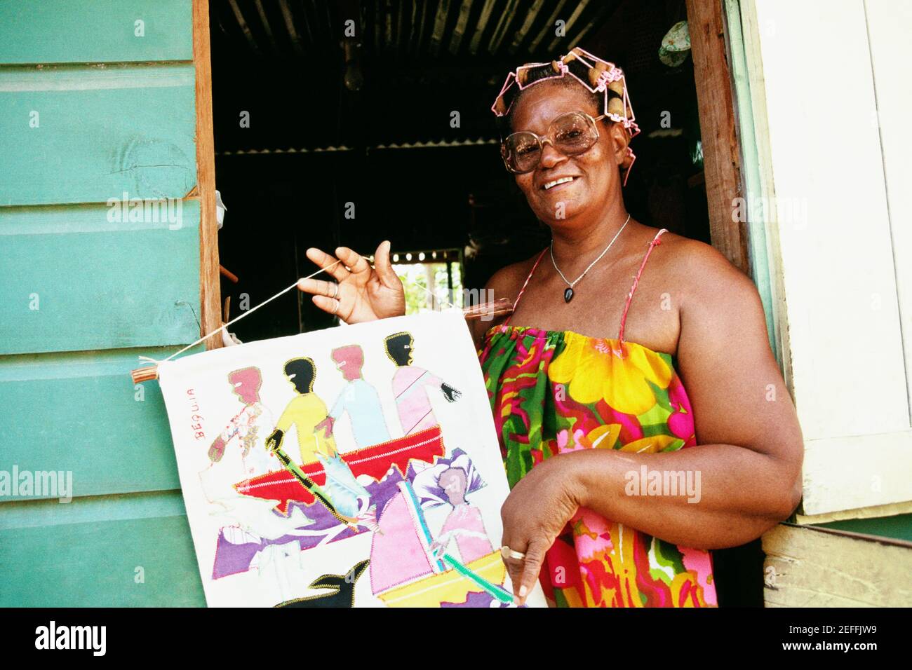 Eine afroamerikanische Frau posiert mit einem Gemälde Stockfoto