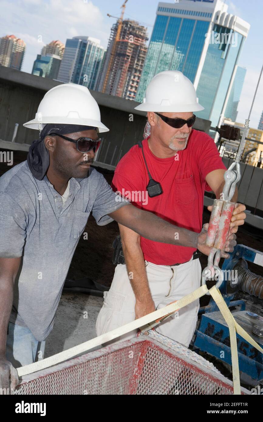 Nahaufnahme von zwei männlichen Bauarbeitern, die an einer Baustelle arbeiten Standort Stockfoto