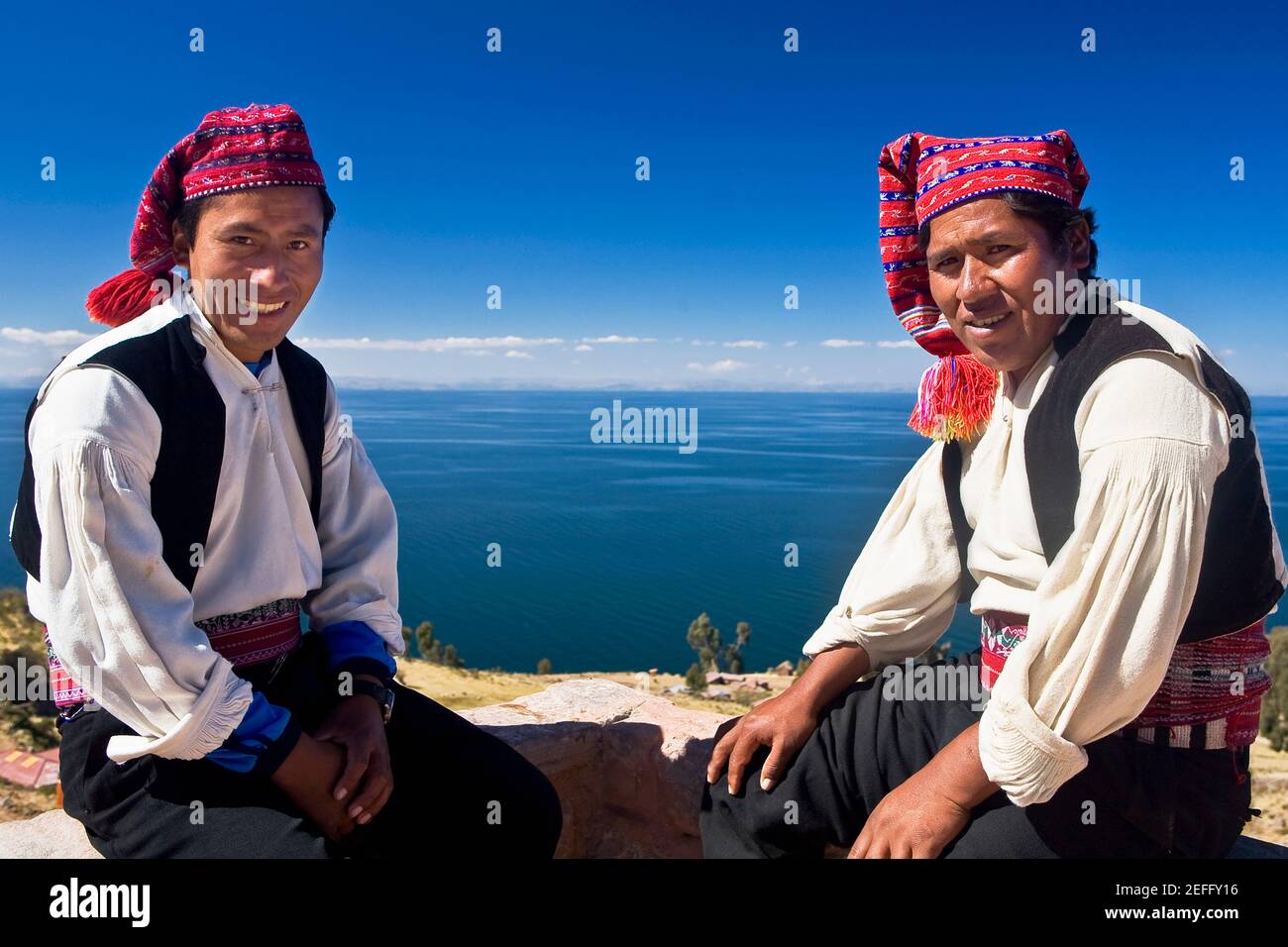 Porträt zweier junger Männer, die sitzen, Taquile Island, Titicacasee, Puno, Peru Stockfoto