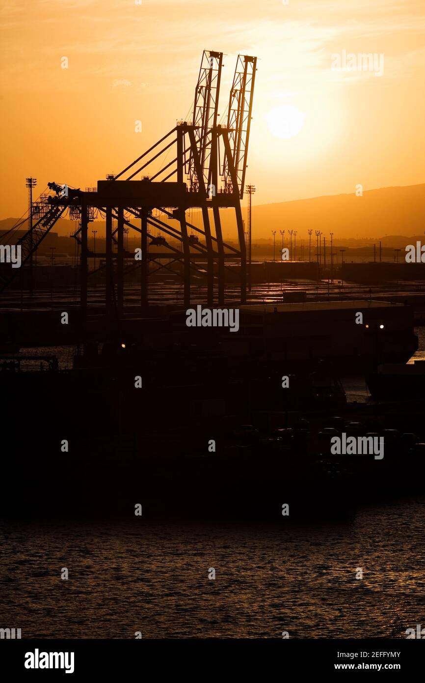 Silhouette von Kränen an einem kommerziellen Dock Stockfoto