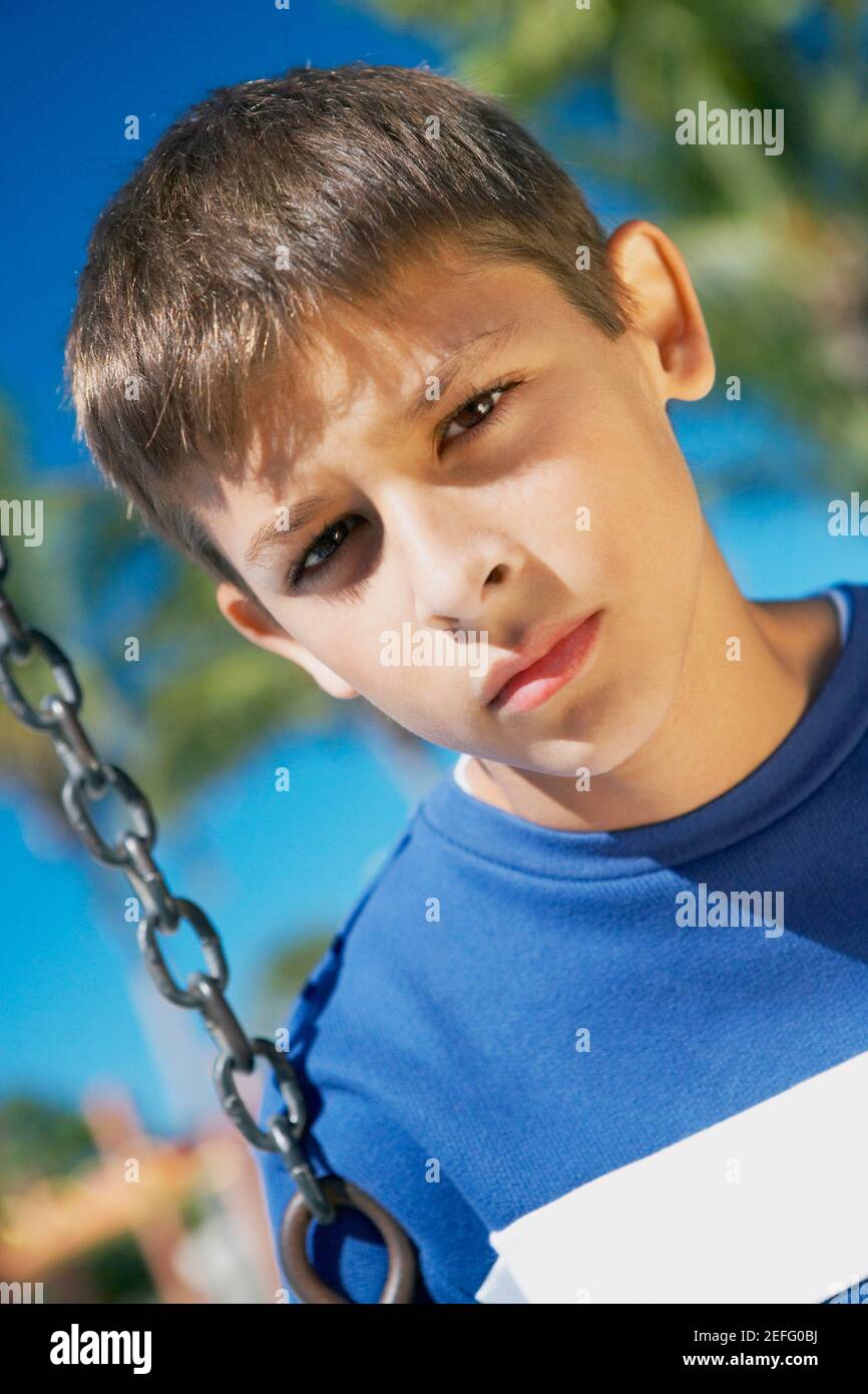 Porträt eines Jungen im Teenageralter auf einer Schaukel Stockfoto
