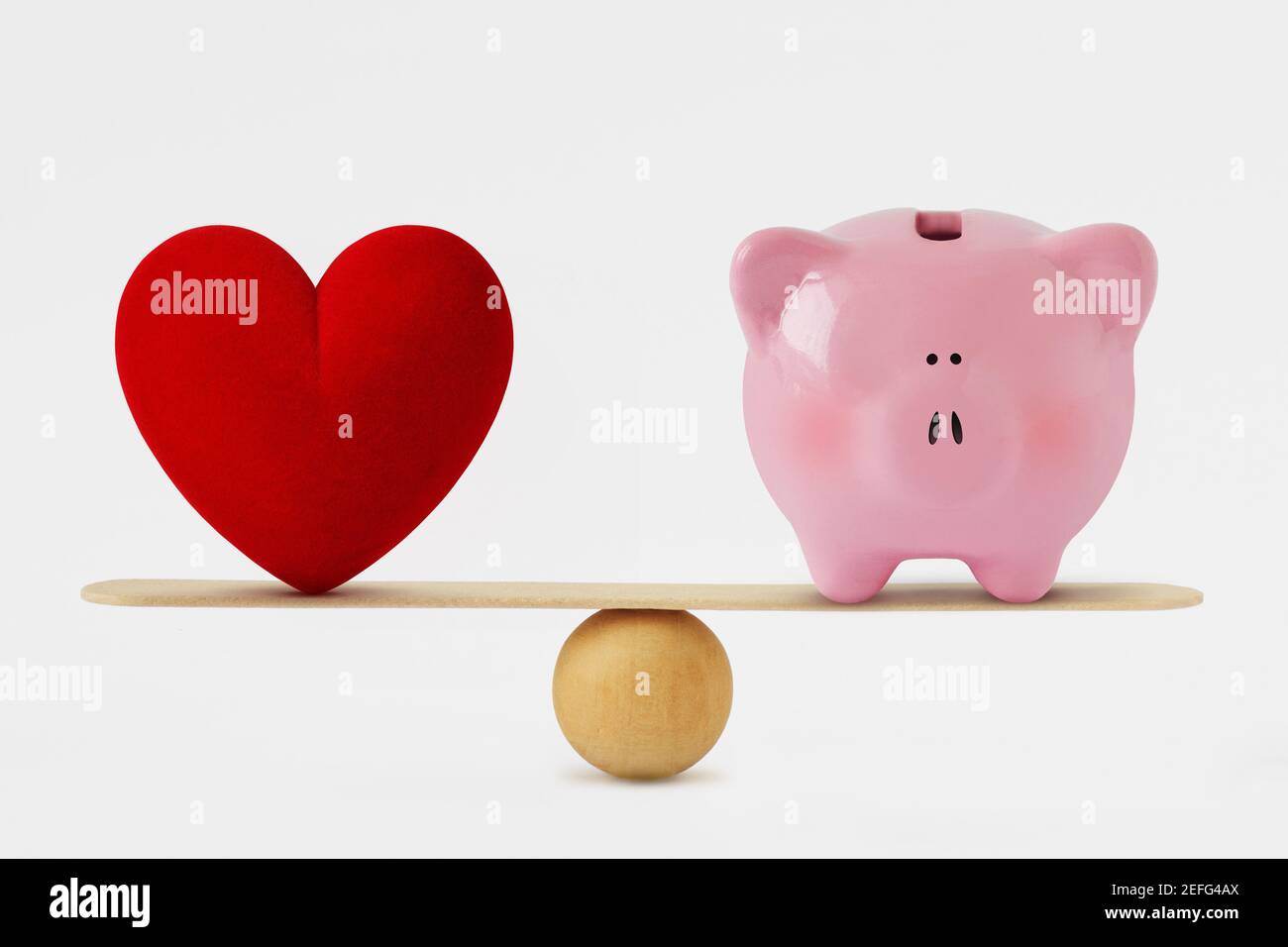 Herz und Sparschwein auf Waage - Balance between Liebe und Geld Stockfoto