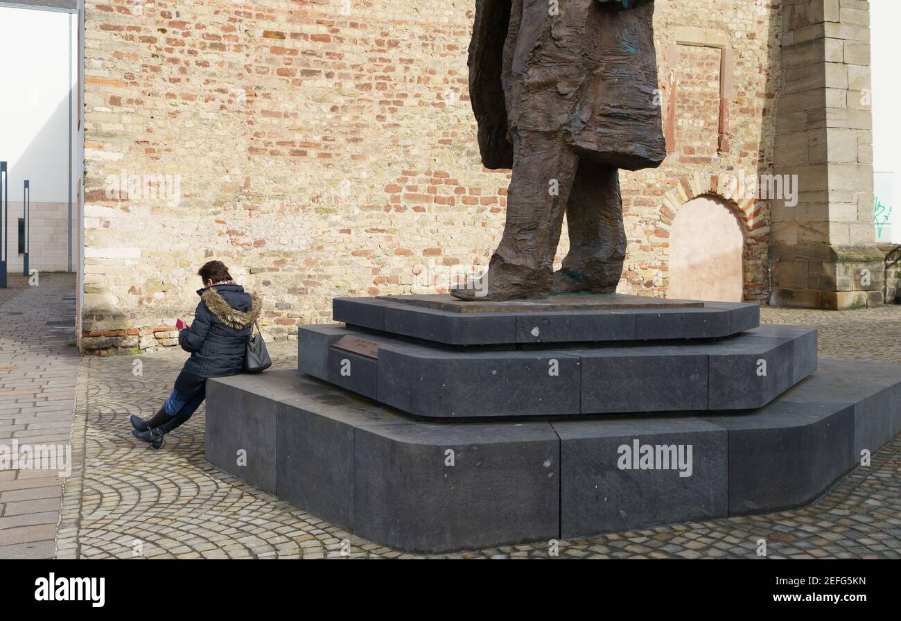 16. Februar 2021, Rheinland-Pfalz, Trier: Eine Frau sitzt auf dem Sockel der Karl-Marx-Statue am Simeonstiftplatz. Die Statue wurde am 5. Mai 2018 anlässlich des 200th. Jahrestages der Geburt von Karl Marx in seiner Heimatstadt enthüllt. Der Philosoph, Ökonom, Journalist und Autor des "Kapitals", der Kritik der kapitalistischen Gesellschaft des 19th. Jahrhunderts, wurde am 5. Mai 1818 in Trier geboren. Foto: Andreas Arnold/dpa Stockfoto