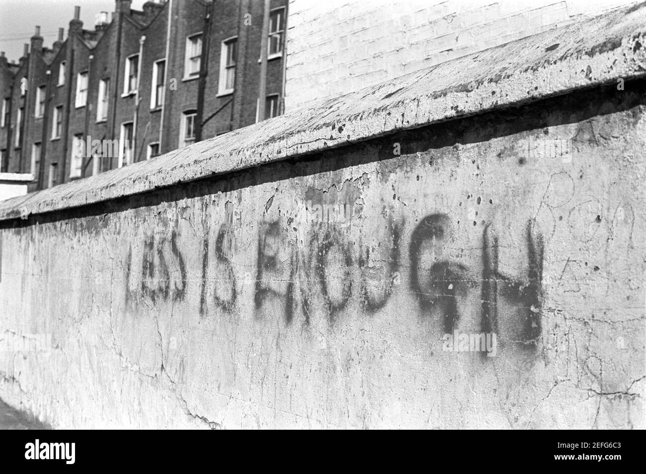 Großbritannien, West London, Notting Hill, 1973. Grafitti sagt 'weniger ist genug'. Stockfoto