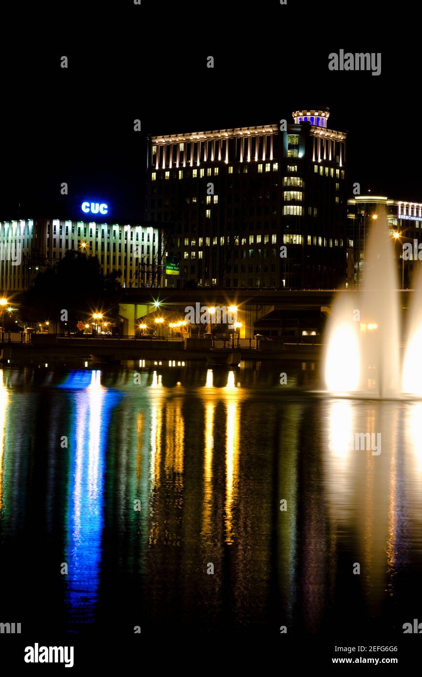 Nachts beleuchtete Brunnen vor Gebäuden, Orlando, Florida, USA Stockfoto