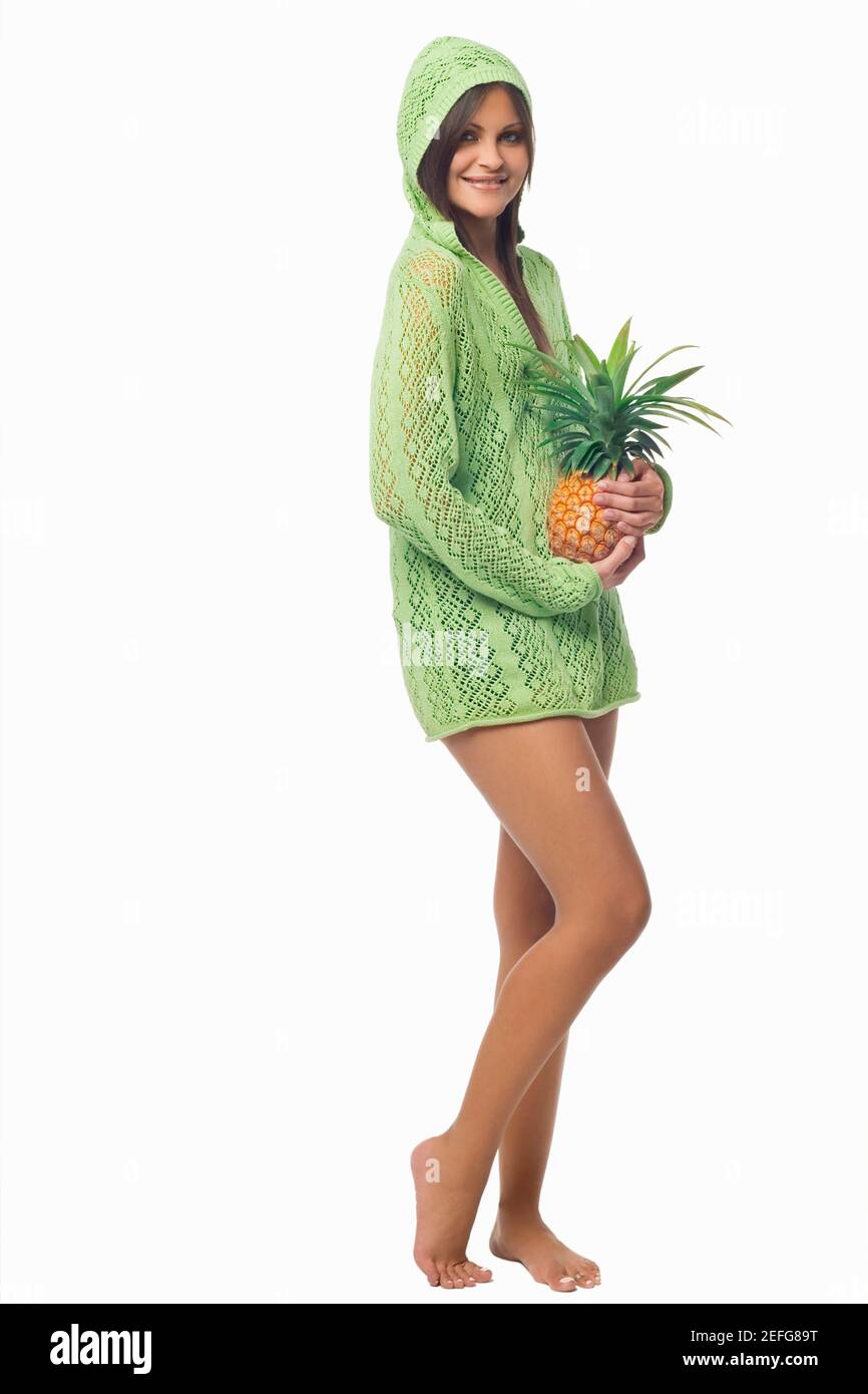 Porträt einer jungen Frau stehen und halten eine Ananas Stockfoto