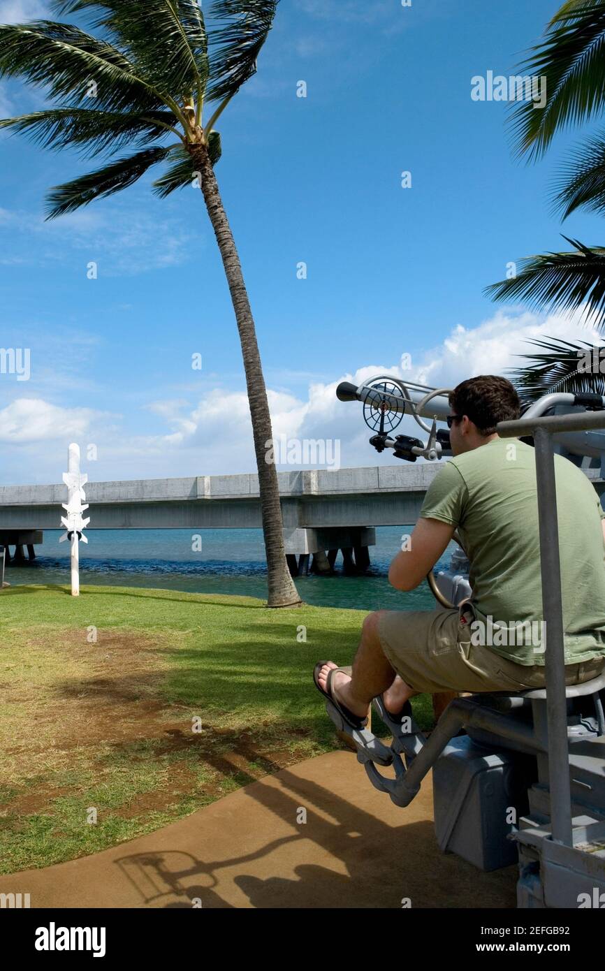 Rückansicht eines Mannes, der auf einer Artilleriekanone sitzt, Pearl Harbor, Honolulu, Oahu, Hawaii-Inseln, USA Stockfoto