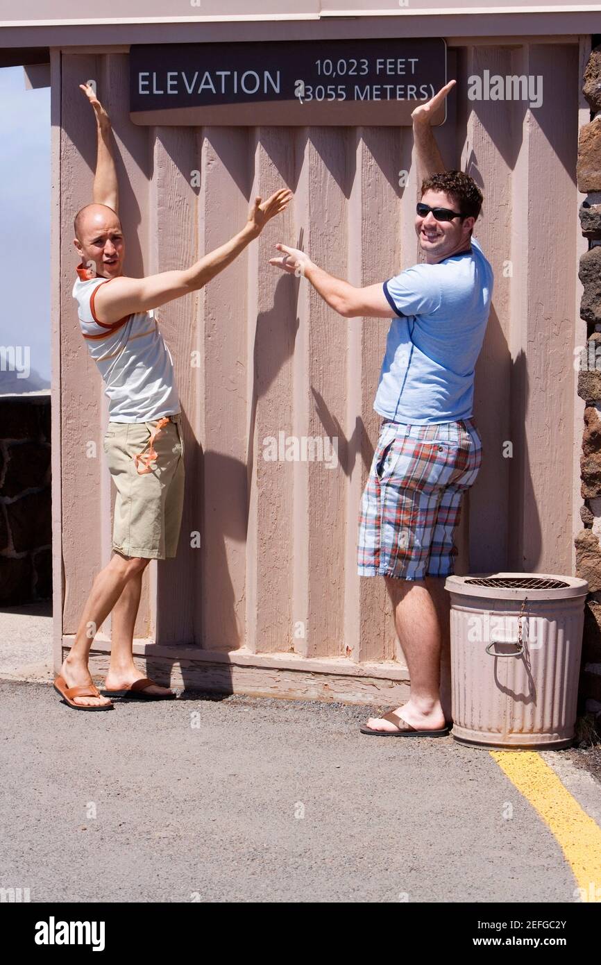 Zwei Männer mittleren Erwachsenen posieren gegen eine Wand, Haleakala National Park, Maui, Hawaii-Inseln, USA Stockfoto