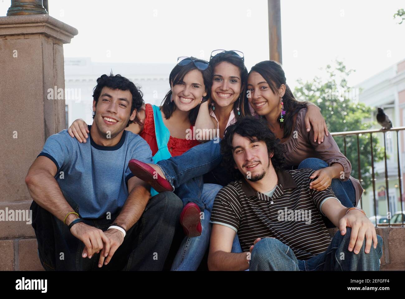 Porträt von drei jungen Frauen Lächeln mit zwei jungen Männern Stockfoto