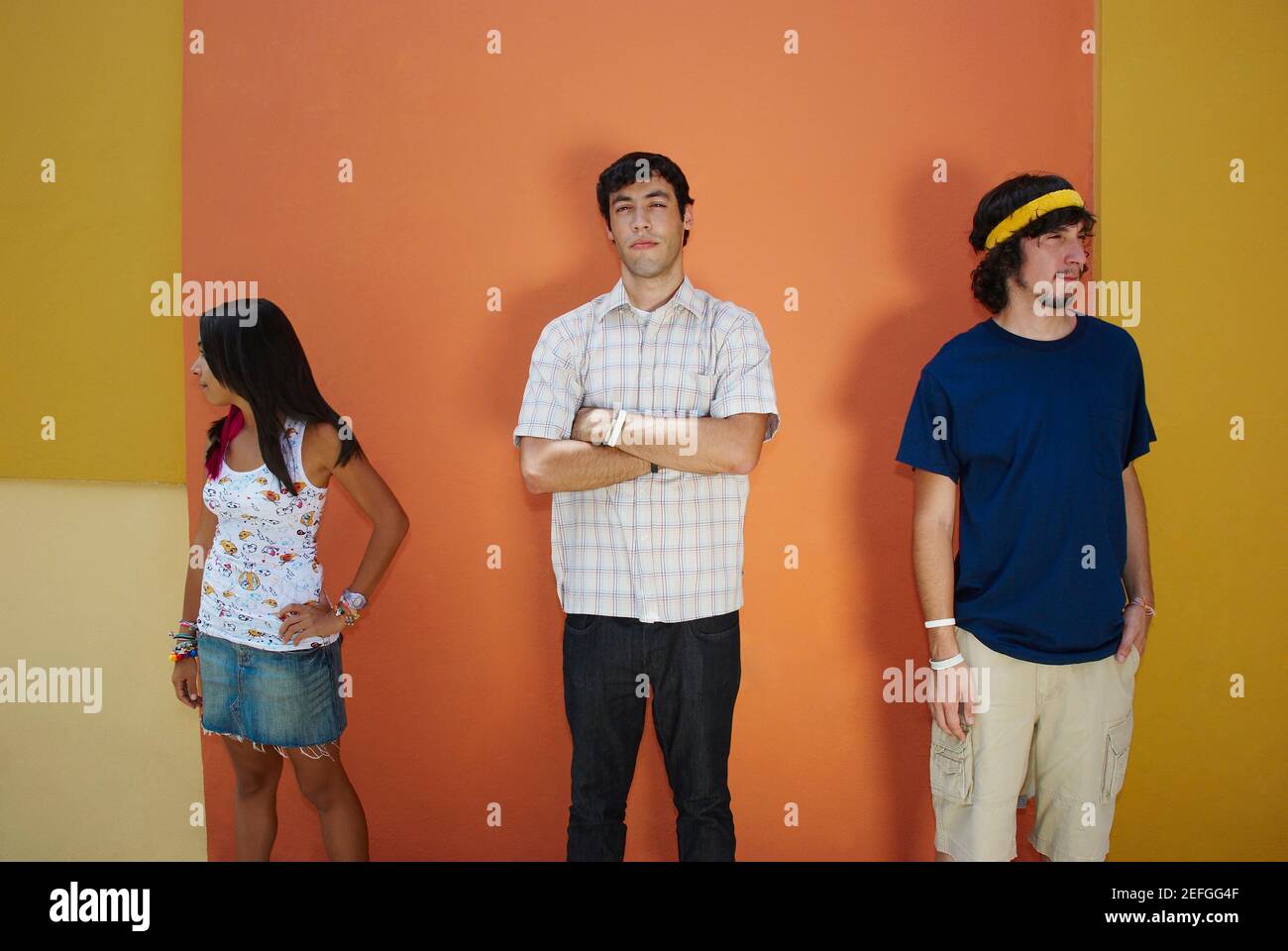 Zwei junge Männer mit einer jungen Frau stehen und blickte ernst Stockfoto