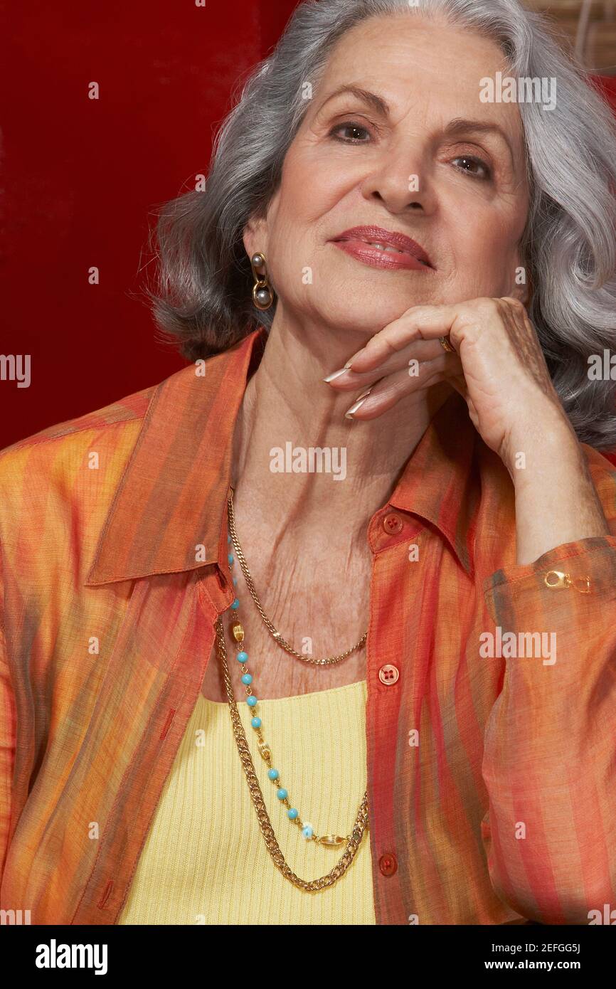 Nahaufnahme einer älteren Frau lächelnd mit der Hand am Kinn Stockfoto